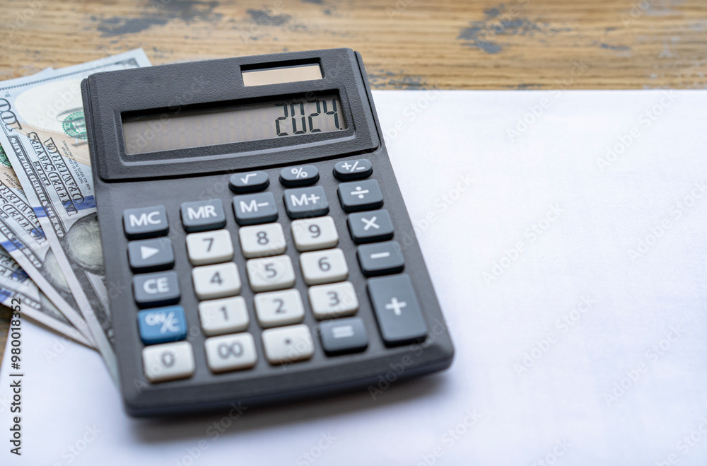 Calculator with the number 2024 on the display US dollars. Concept of finance, taxes, savings and economic crisis. Calculator with the number 2024 on the display US dollars. Concept of finance, taxes, savings and economic crisis.