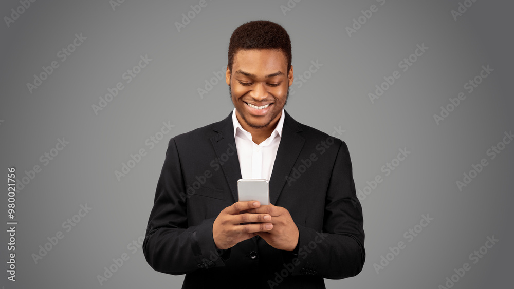 Online Chat. Happy black guy in suit using mobile phone, texting email to clients, white background, panorama Online Chat. Happy black guy in suit using mobile phone, texting email to clients, white background, panorama
