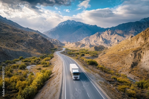 Aerial shot of a delivery truck driving through mountain roads photo