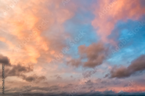 A beautiful sky tinted by the sun leaving vibrant shades of gold, pink, blue and multicolored. Clouds in the twilight evening and morning sky. Cloudy sky background in the evening, and during the day.