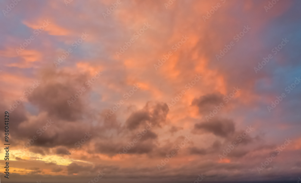 Obraz premium A beautiful sky tinted by the sun leaving vibrant shades of gold, pink, blue and multicolored. Clouds in the twilight evening and morning sky. Cloudy sky background in the evening, and during the day.