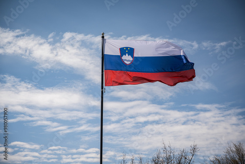 Waving isolated Slovenian red, blue, white flag in wind on pole.