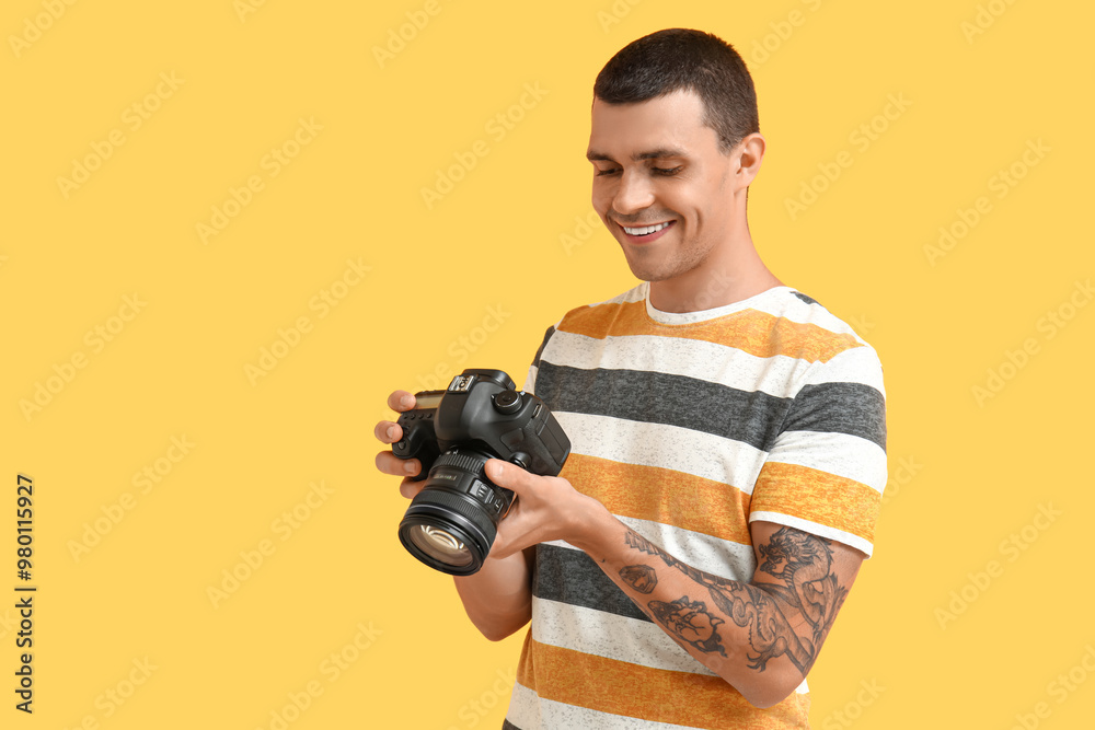 Male photographer with modern camera on yellow background Male photographer with modern camera on yellow background