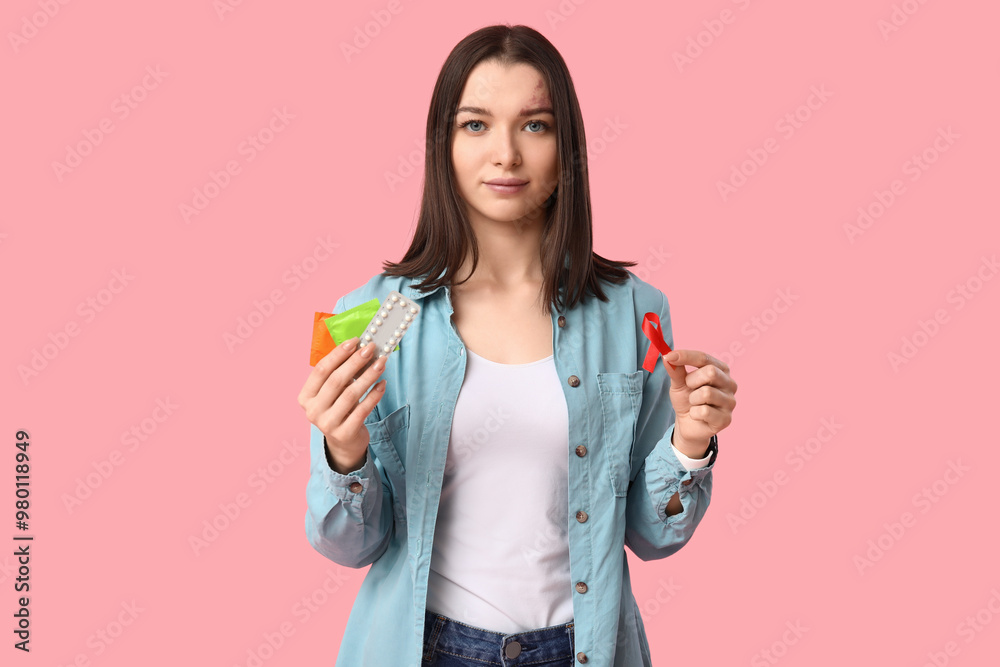 Beautiful young woman with contraceptive pills, red ribbon and condoms on pink background. AID awareness concept Beautiful young woman with contraceptive pills, red ribbon and condoms on pink background. AID awareness concept