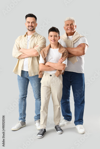 Teenage boy with his dad and grandfather on light background