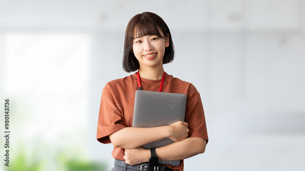 ノートパソコンを抱えて持つ若い女性・ビジネスウーマン ノートパソコンを抱えて持つ若い女性・ビジネスウーマン