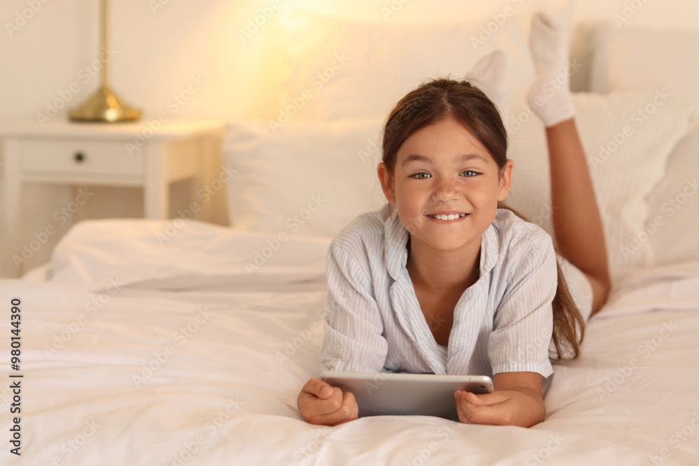Little girl watching cartoons on tablet computer in bedroom Little girl watching cartoons on tablet computer in bedroom