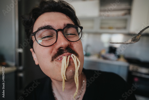 Murais de parede Close-up of a man wearing glasses and mustache, playfully eating spaghetti