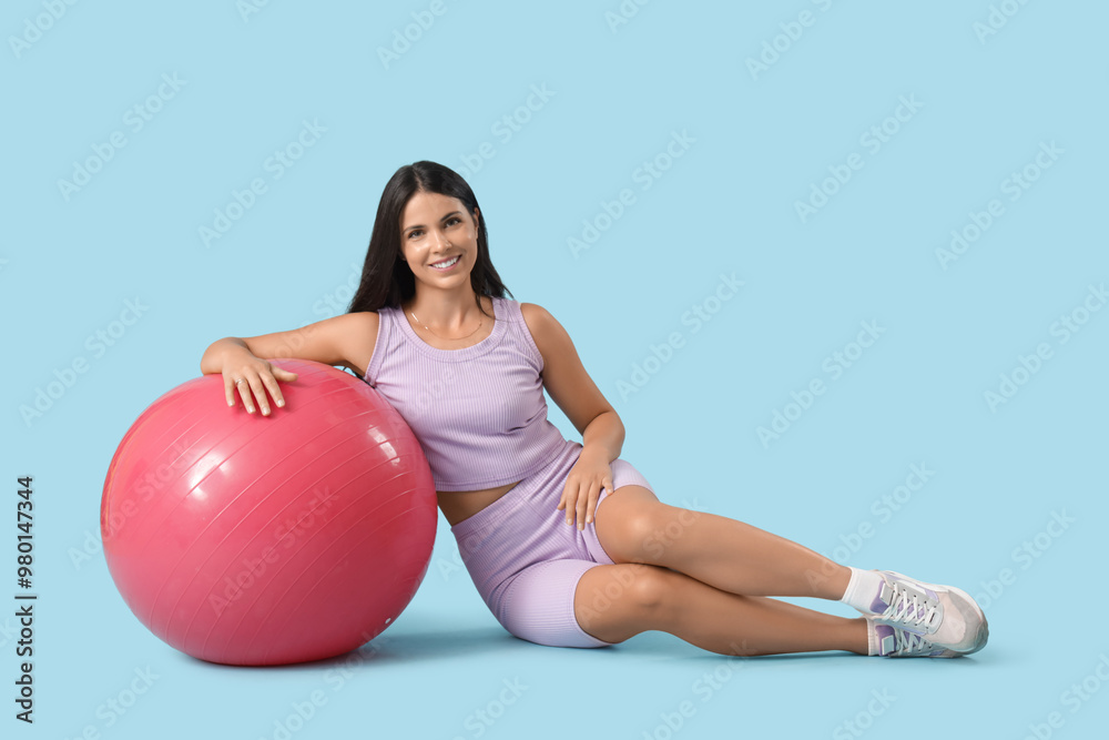 Portrait of sporty young woman with fitball on blue background Portrait of sporty young woman with fitball on blue background