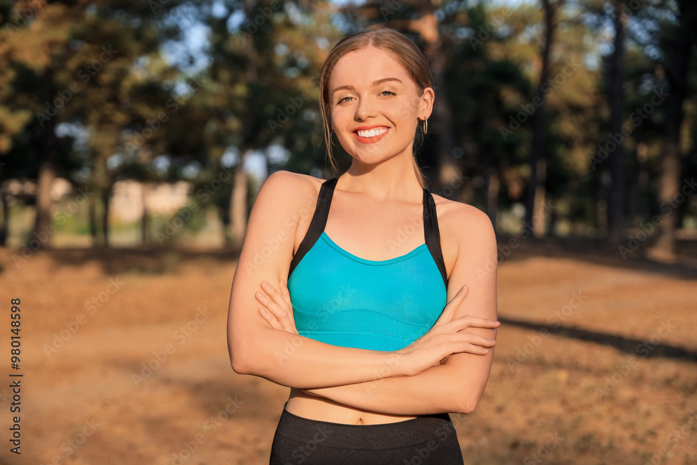 Sporty young woman smiling in park at sunset Sporty young woman smiling in park at sunset