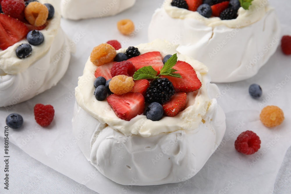 Pavlova cake (meringue dessert) with whipped cream and fresh berries on table, closeup Pavlova cake (meringue dessert) with whipped cream and fresh berries on table, closeup