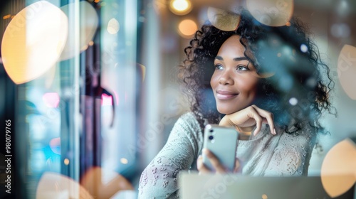 A woman  looking out the window while using a smartphone