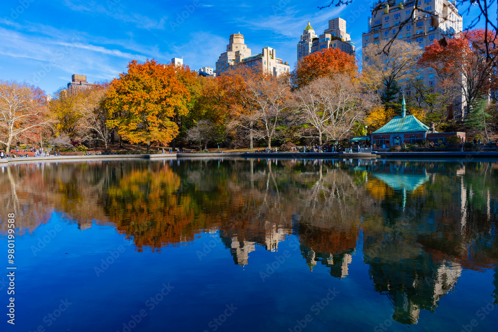 New York City, USA - November 20, 2023: Autumn city landscape of central park in fall season with beautiful cityscape and reflection in river New York City, USA - November 20, 2023: Autumn city landscape of central park in fall season with beautiful cityscape and reflection in river