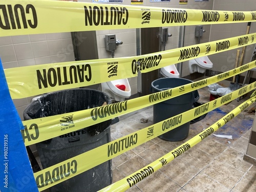 Φωτογραφία Yellow caution tape in front of a closed public men's bathroom