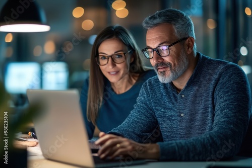 Collaborative Business Partners Working Together on Laptop at Desk