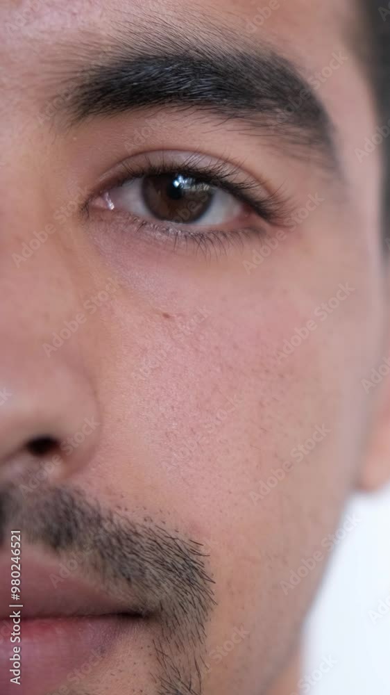 Vertical video. Sight correction. Vision medicine. Ophthalmology clinic. Calm man half face portrait with healthy beautiful brown color iris eye.