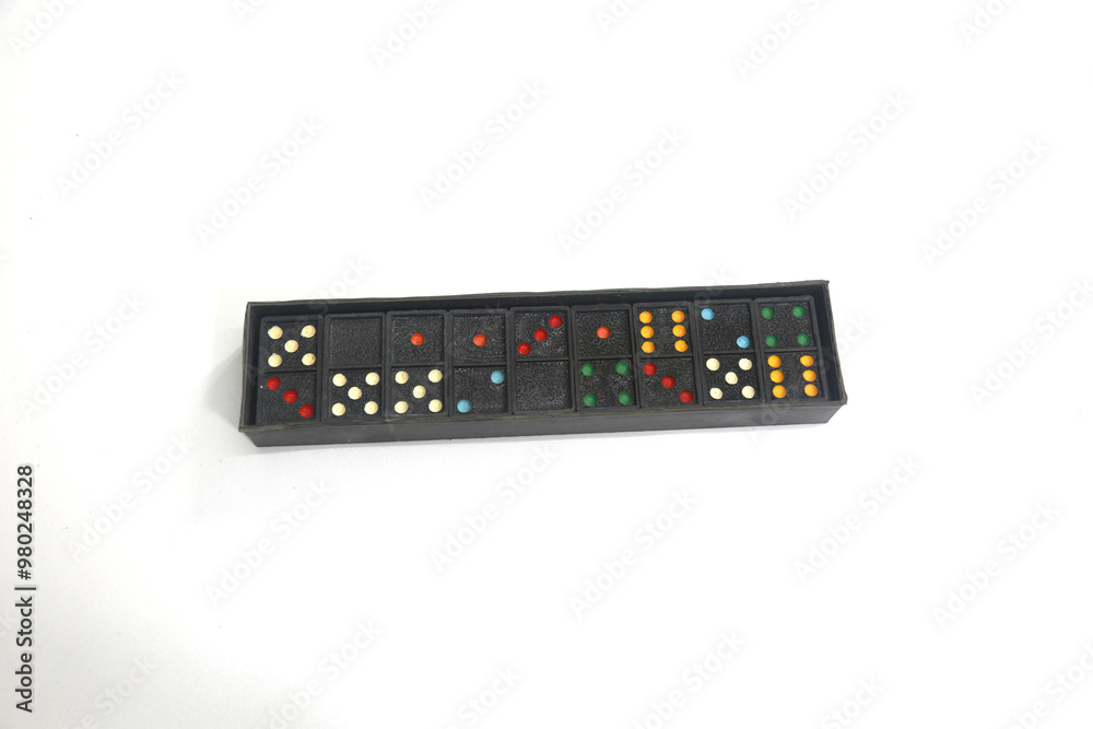 Black plastic dominoes placed on a colored background. Black plastic dominoes placed on a colored background.
