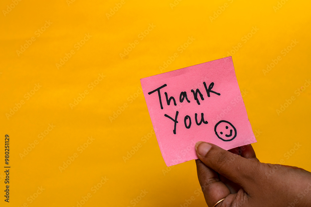 Woman Holding Pink Thank You Note with Empty Space on Yellow Background Woman Holding Pink Thank You Note with Empty Space on Yellow Background