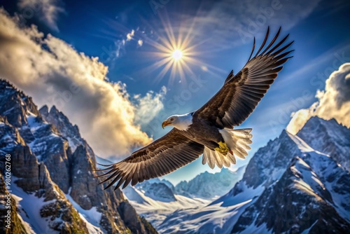 Majestic eagle spreads wings, soaring effortlessly above rugged mountain peaks, set against a brilliant blue sky with only a few wispy clouds.