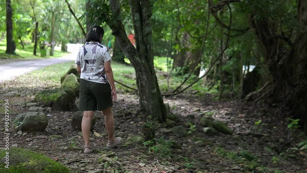 Asian woman walking along the river in the forest Asian woman walking along the river in the forest