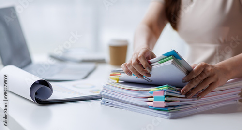 фотографія Adult businesswoman or auditor examining documents and laptop