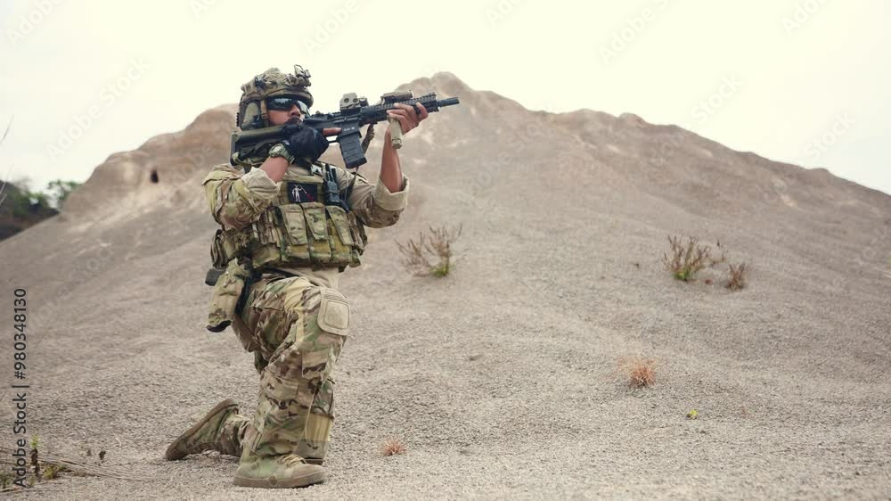 Bearded male soldier of special forces holding machine gun patrolling a dangerous border area sits at alert, guarded and ready to fight. Bearded male soldier of special forces holding machine gun patrolling a dangerous border area sits at alert, guarded and ready to fight.