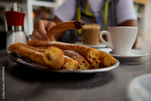 Churros popular delicious spanish food with hot chocolate and coffe on restaurant table with blured background