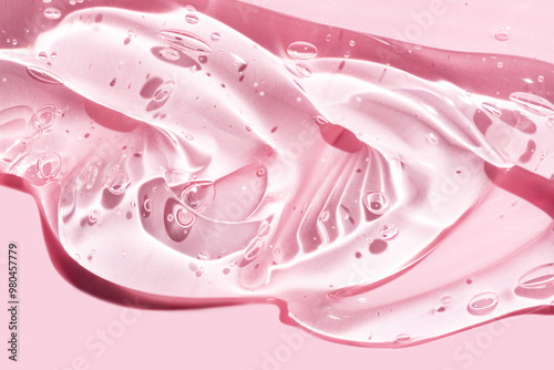 Liquid gel abstract cosmetic in pink background. Smear of transparent moisturizing product