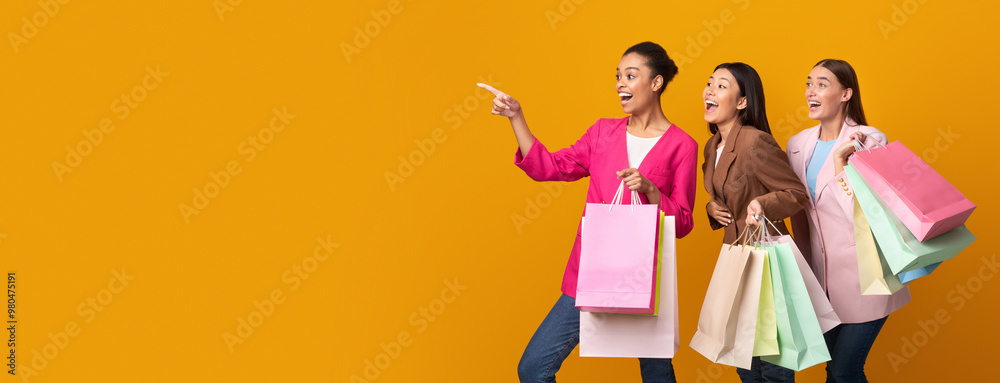 © Prostock-studio - Big Sales. Three Excited Girls With Shopping Bags Pointing Fingers Looking At Copyspace Standing In Studio On Yellow Background. Panorama © Prostock-studio - Big Sales. Three Excited Girls With Shopping Bags Pointing Fingers Looking At Copyspace Standing In Studio On Yellow Background. Panorama