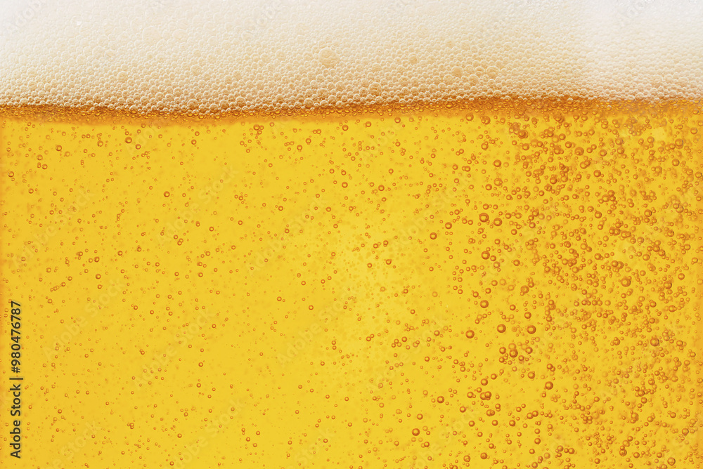 Close-up of yellow beer texture with white foam on top Close-up of yellow beer texture with white foam on top