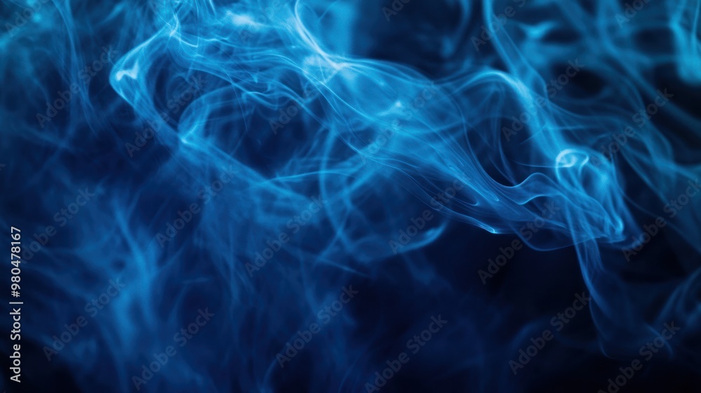 Obraz premium Abstract blue smoke or mist flowing and twisting on a dark background, adding a mysterious atmosphere Close-up photo with clean background