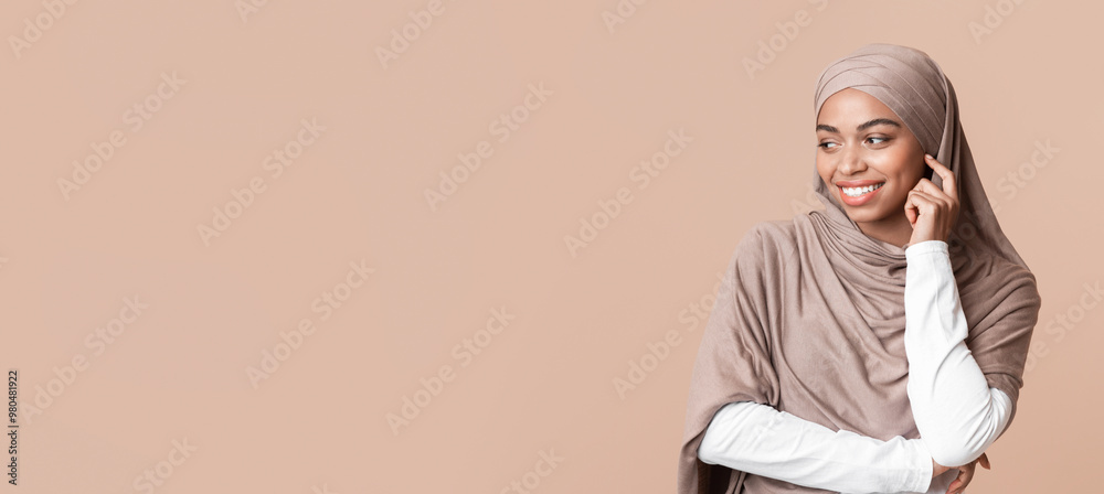 Interested afro arabic girl in hijab looking away at copy space on yellow background and touching her face in excitement, panorama Interested afro arabic girl in hijab looking away at copy space on yellow background and touching her face in excitement, panorama