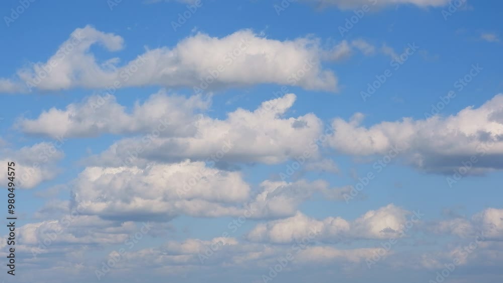 White fluffy clouds drift across a clear blue sky, evoking peace and tranquility. Ideal for backgrounds, nature themes, and relaxation concepts.