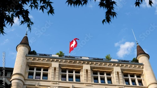 Wallpaper Mural Swiss Flag Waving on an Old Building with Tower Against Sky in a Sunny Summer Day in Lausanne, Vaud, Switzerland. Torontodigital.ca