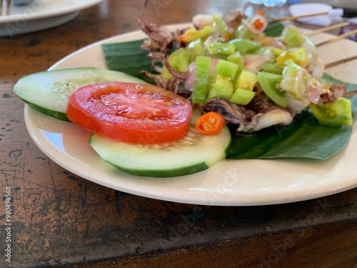 Balinese Grilled Squid with Dabu Dabu Chili Sauce. Spicy Indonesian condiment sambal made of tomato, garlic and shallot with lemon basil photo