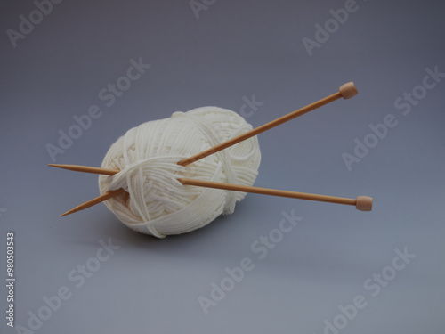 knitting balls in a basket with knitting needles on gray background. Set for the hobby of knitting warm clothes or toys. Concept needlework