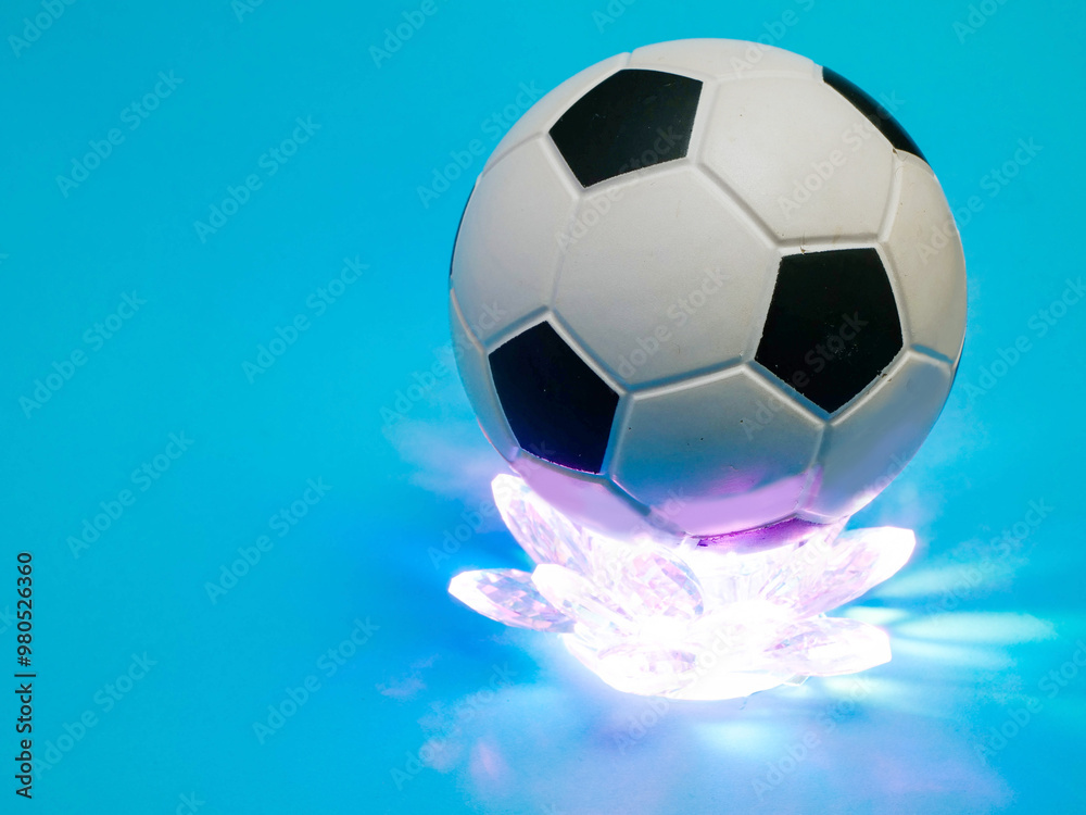 Fototapeta premium Soccer or football on a glowing crystal glass basement, blue color background. Abstract sport background. Old style ball design.