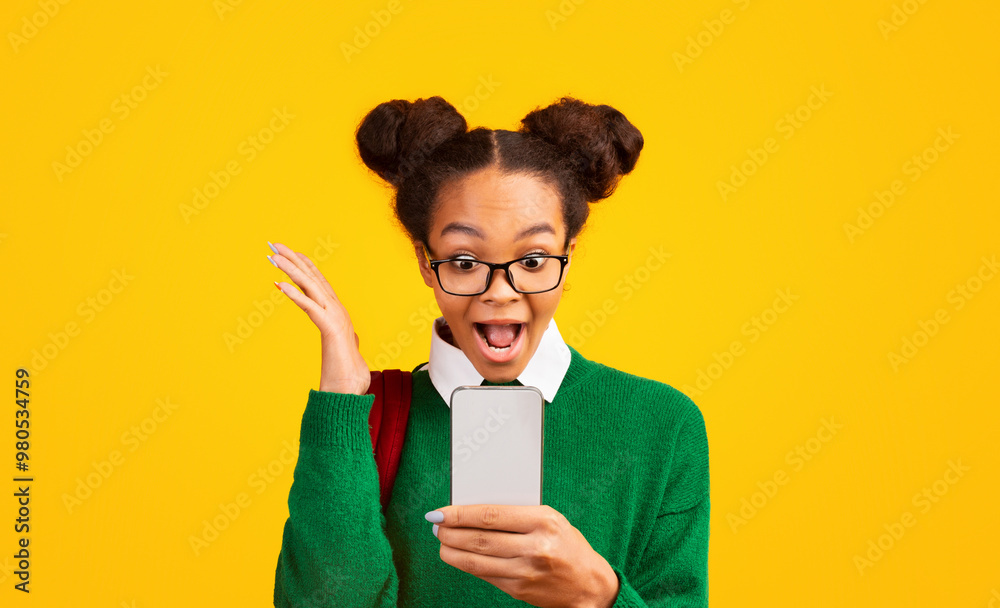 Massive Sale. Excited black teen girl using smartphone, screaming with joy on yellow background. Free space, panorama Massive Sale. Excited black teen girl using smartphone, screaming with joy on yellow background. Free space, panorama