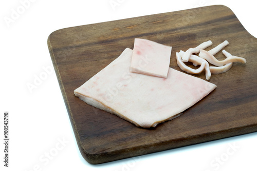 Uncooked pork rind on wooden cutting board isolated on white background with clipping path stacking photo