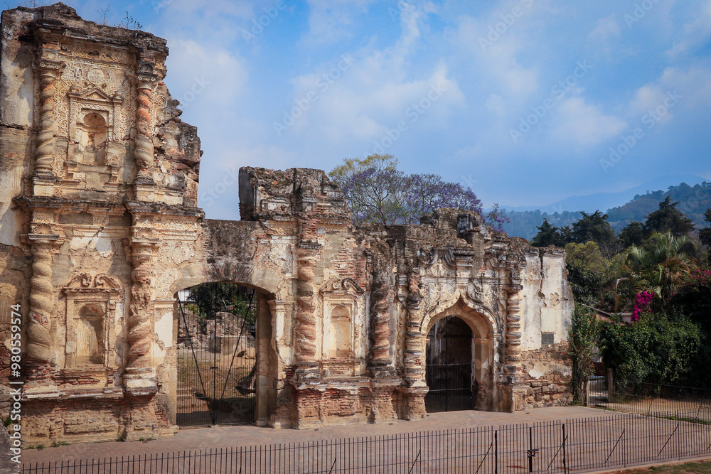Historic ruins of Antigua, Guatemala showcase intricate stonework against a vibrant sky