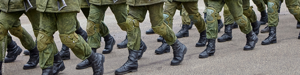 Soldiers marching in formation during a military parade on a clear day in an urban setting Soldiers marching in formation during a military parade on a clear day in an urban setting