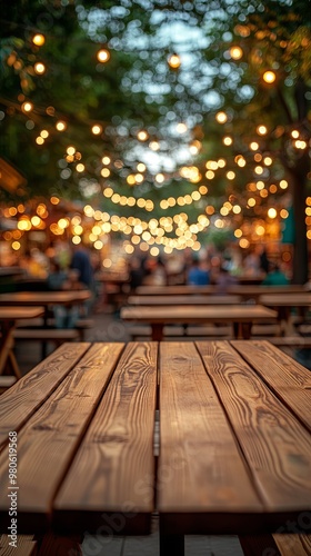 Empty wooden tables on blurred food truck festival and bright decoration lights