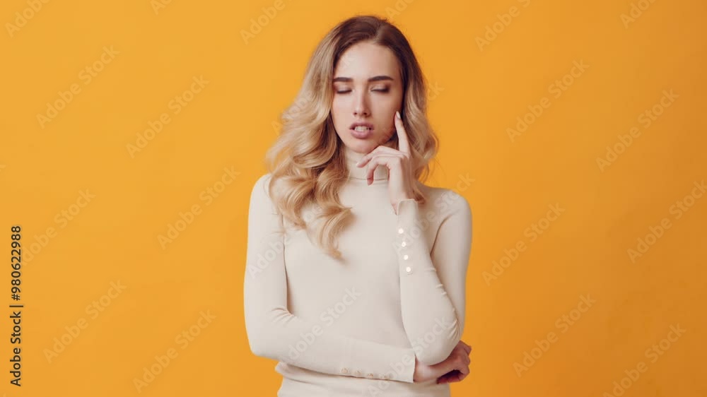 A young woman stands with a finger on her chin, looking thoughtfully to the side. Her soft curls frame her face against a bright yellow backdrop, conveying a moment of contemplation. A young woman stands with a finger on her chin, looking thoughtfully to the side. Her soft curls frame her face against a bright yellow backdrop, conveying a moment of contemplation.