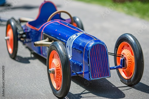 Close-up of a colorful soapbox, race car on a track, showcasing speed and competition at a motorsport event, evoking the excitement of classic racing.