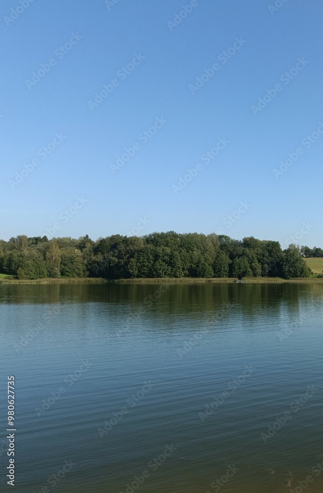Bubiai lake during sunny day. Sunny day with white and gray clouds in blue sky. Wavy lake. Horizon over water. Bubiu ezeras. Bubiai lake during sunny day. Sunny day with white and gray clouds in blue sky. Wavy lake. Horizon over water. Bubiu ezeras.