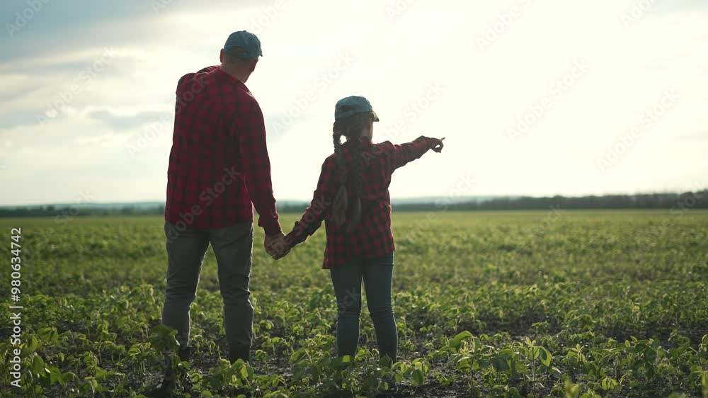 Family farmer crop field. Father daughter holding hand bonding over agronomy. Learning crop farm together. Family values agronomy. Father teaching daughter about crops. Agronomy family walk at sunset. Family farmer crop field. Father daughter holding hand bonding over agronomy. Learning crop farm together. Family values agronomy. Father teaching daughter about crops. Agronomy family walk at sunset.