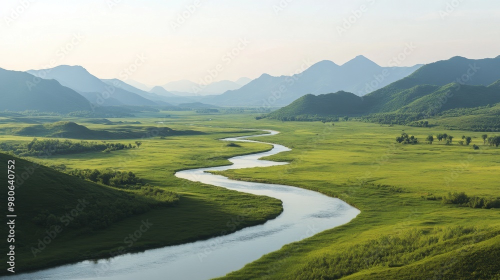A wide, winding river cutting through a lush green valley, with distant mountains in the background under a clear sky. A wide, winding river cutting through a lush green valley, with distant mountains in the background under a clear sky.