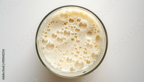 Blender cup with soy milk, top view. A freshly prepared plant-based milk drink with bubbles on the surface