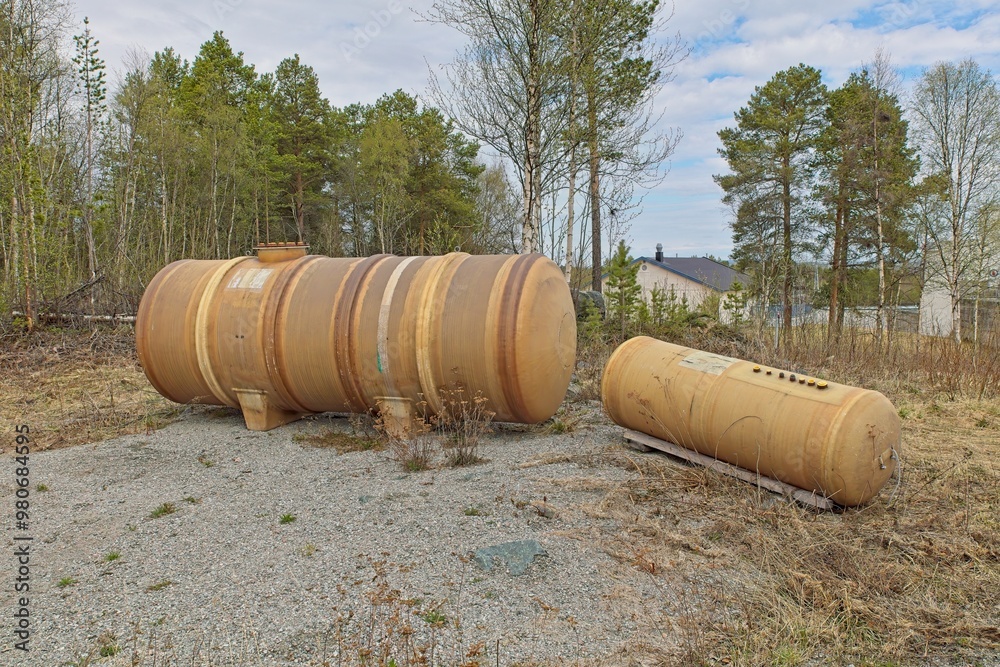 Old used large water containers outdoors. Old used large water containers outdoors.