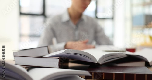 Student woman with many books preparing for exam. Studying law from scratch on your own
